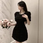Đầm đen cổ tròn viền đá khoét vai eo
