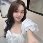 Đầm trắng tay phồng nơ ngực đính đá thân