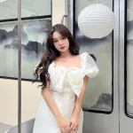 Đầm trắng tay phồng nơ ngực đính đá thân