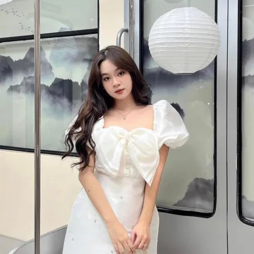 Đầm trắng tay phồng nơ ngực đính đá thân