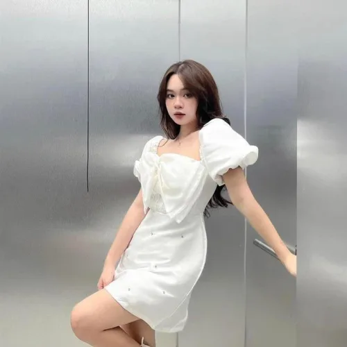 Đầm trắng tay phồng nơ ngực đính đá thân