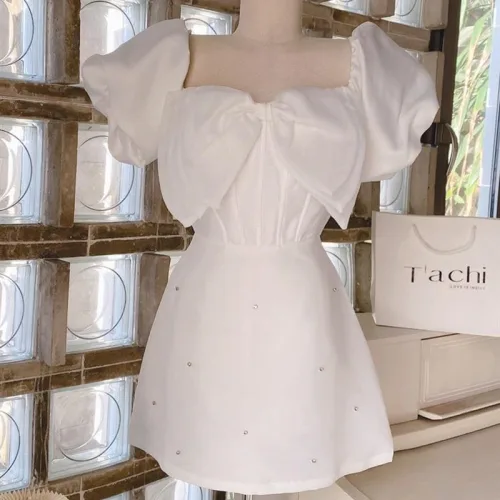 Đầm trắng tay phồng nơ ngực đính đá thân